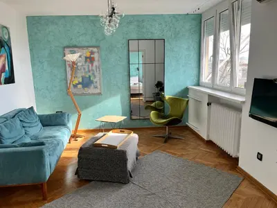 a living room with a couch and a mirror at Gajba Apartment in Belgrade