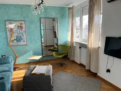 a living room with a couch and a mirror at Gajba Apartment in Belgrade
