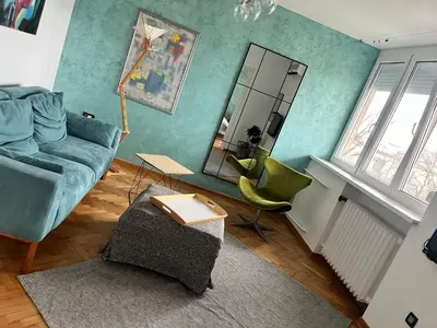 a living room with a blue couch and a mirror at Gajba Apartment in Belgrade