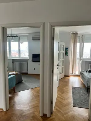 a living room with a bed and a living room with a couch at Gajba Apartment in Belgrade