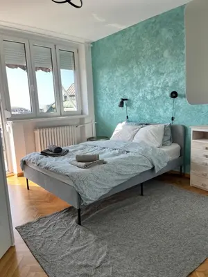 a bedroom with a bed with a blue wall at Gajba Apartment in Belgrade