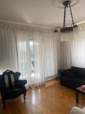 a living room with a couch and a chair at Apartman Lux in Belgrade