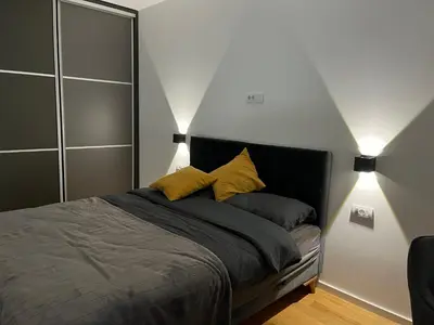 a bedroom with a bed with two lamps on it at Sunnyhome in Belgrade