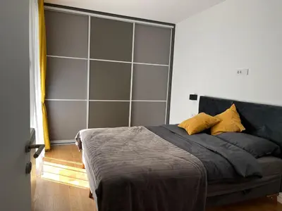 a bedroom with a bed with a large headboard at Sunnyhome in Belgrade