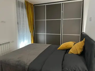 a bedroom with a large bed with yellow pillows at Sunnyhome in Belgrade