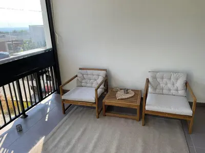 two chairs and a coffee table on a balcony at Forest View Apartment in Rogača
