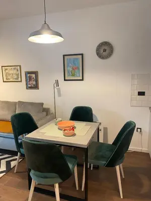 a dining room with a table and green chairs at Forest View Apartment in Rogača