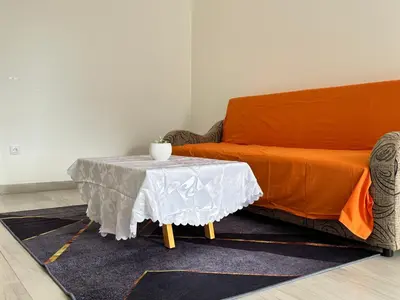 a bed and a table with a white table cloth on it at Belgrade Airport Luxury Single in Surčin