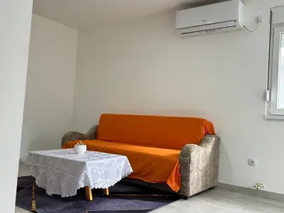 an orange couch with a table in a room at Belgrade Airport Luxury Single in Surčin