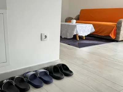 a pile of shoes on the floor next to a table at Belgrade Airport Luxury Single in Surčin