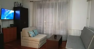 a living room with a couch and a chair and a tv at Ogi apartman in Belgrade