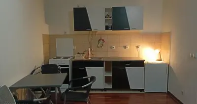 a kitchen with white appliances and a table and chairs at Ogi apartman in Belgrade