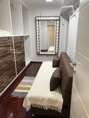 a living room with a couch and a mirror at Mona Lux apartman in Arandjelovac