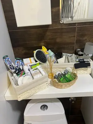 a bathroom shelf with baskets on top of a toilet at Mona Lux apartman in Arandjelovac