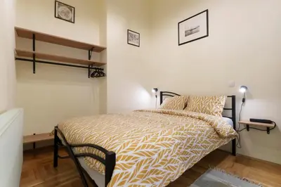 a bedroom with a bed with a yellow and white comforter at Apartment Nedeljica in Belgrade