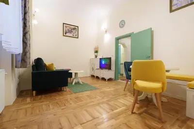 a living room with a yellow chair and a television at Apartment Nedeljica in Belgrade