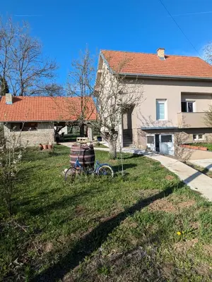 a house with a bike parked in the yard at Vila Restart Čortanovci in Čortanovci