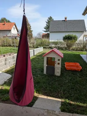 a red umbrella in a yard with a dog house at Vila Restart Čortanovci in Čortanovci
