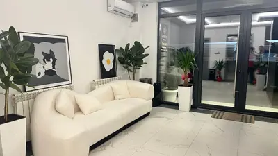 a living room with a white couch and plants at KIMMIY Garni Attic Rooms near Belgrade Airport in Beograd
