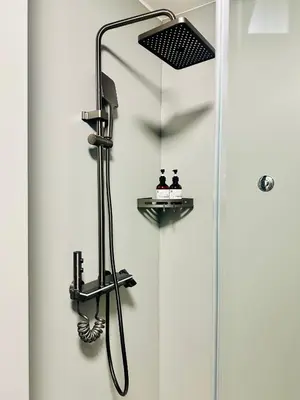 a shower in a bathroom with a shower head at KIMMIY Garni Attic Rooms near Belgrade Airport in Beograd