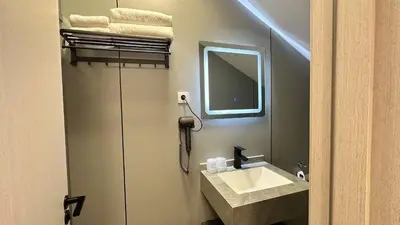 a bathroom with a sink and a mirror at KIMMIY Garni Attic Rooms near Belgrade Airport in Beograd