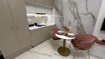 a white kitchen with a table and two chairs at Luxi TOP in Belgrade