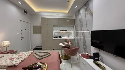 a room with a bed and a table and a kitchen at Luxi TOP in Belgrade