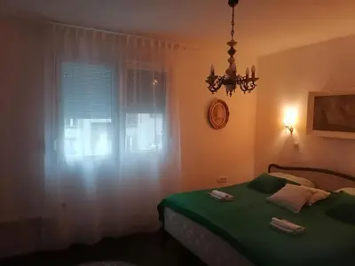 a bedroom with a green bed and a window at Hyde park apartments in Belgrade