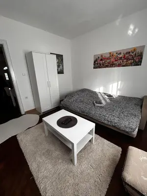 a room with two beds and a white coffee table at Hyde park apartments in Belgrade
