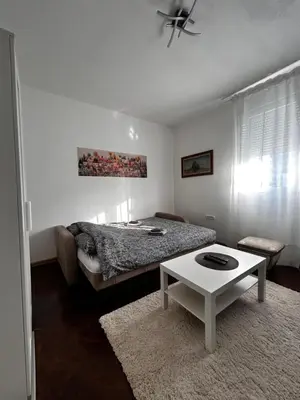 a bedroom with a bed and a white table at Hyde park apartments in Belgrade