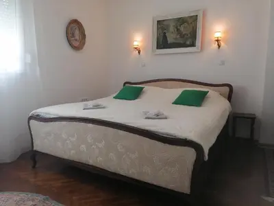 a bedroom with a bed with two green pillows at Hyde park apartments in Belgrade