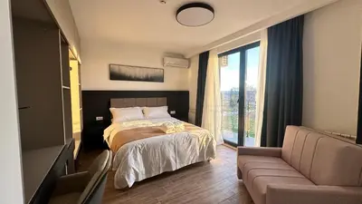 a bedroom with a bed and a couch and a window at KIMMIY HOTEL Garni in Beograd