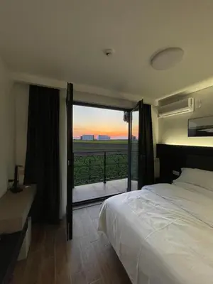 a bedroom with a bed and a window with a view at KIMMIY HOTEL Garni in Beograd