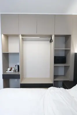 a bedroom with a white bed and a white wall at KIMMIY HOTEL Garni in Beograd