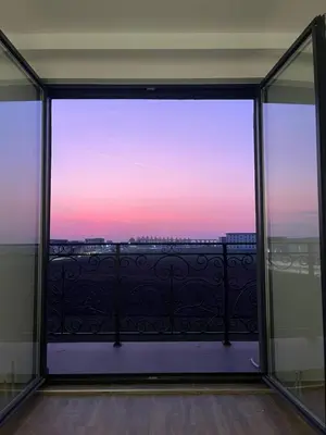 a view from the window of a balcony with a sunset at KIMMIY HOTEL Garni in Beograd