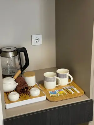 a counter with cups and a coffee pot and cookies at KIMMIY HOTEL Garni in Beograd