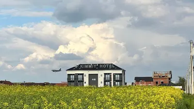 an airplane flying over a building with a field of flowers at KIMMIY HOTEL Garni in Beograd