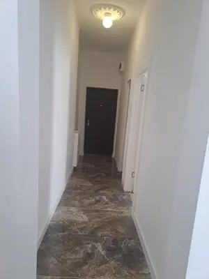 a hallway with white walls and tile floors and a door at Mystique apartment Vračar in Belgrade