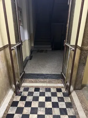 an open door to a hallway with a checkered floor at Mystique apartment Vračar in Belgrade