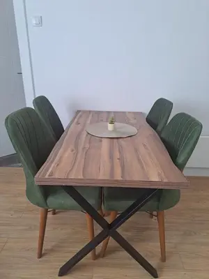 a wooden table with green chairs and a cup on it at Mystique apartment Vračar in Belgrade