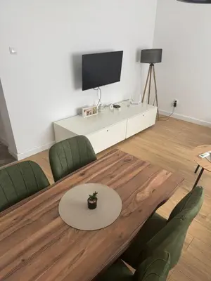 a living room with a table and a tv at Mystique apartment Vračar in Belgrade