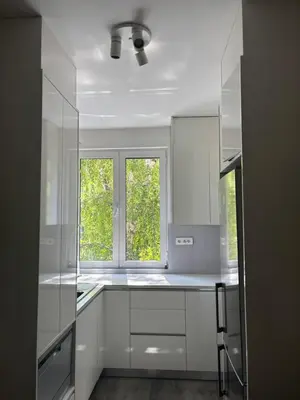 a white kitchen with white cabinets and a window at Apartment Duchess in Belgrade