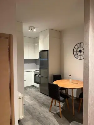 a kitchen with a table and a refrigerator and a table and chairs at Apartment Duchess in Belgrade