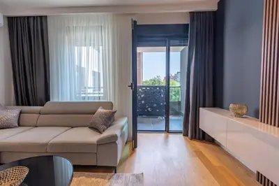 a living room with a couch and a sliding glass door at Park Vila Apartments in Belgrade