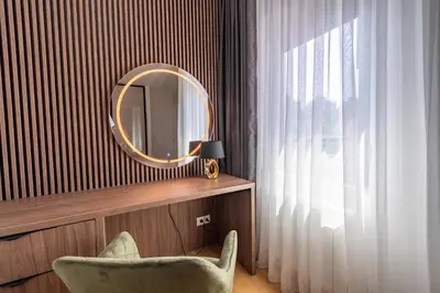a room with a chair and a mirror and a window at Park Vila Apartments in Belgrade