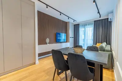 a dining room with a table and chairs and a couch at Park Vila Apartments in Belgrade