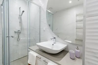 a white bathroom with a sink and a shower at Park Vila Apartments in Belgrade