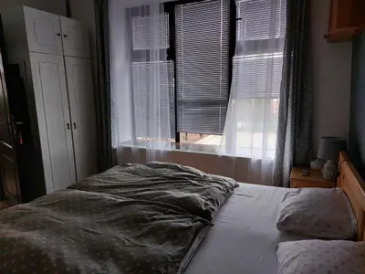 an unmade bed in a bedroom with a window at HostelChe Guest House in Smederevo
