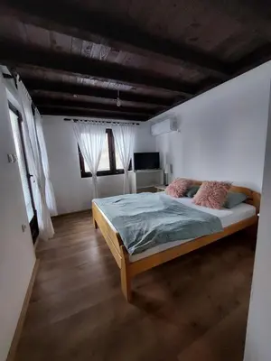 a bedroom with a bed and two windows at HostelChe Guest House in Smederevo