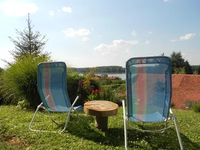 two chairs and a wooden table in the grass at HostelChe Guest House in Smederevo
